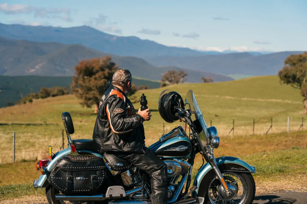 Man sitting on motorbike taking a break at the Southern Cloud Memorial Lookout, Tooma, Snowy Valleys, NSW